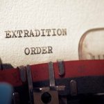 Typewriter typing extradition order document page closeup