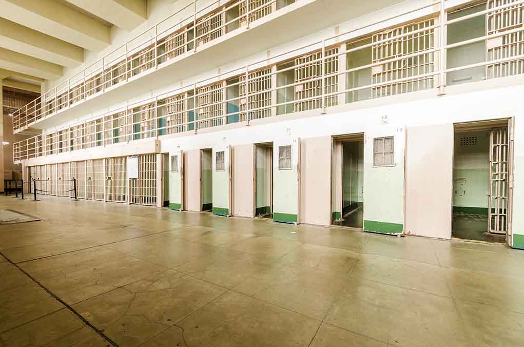206092135 featured image Empty prison cells with open doors, two-story layout.