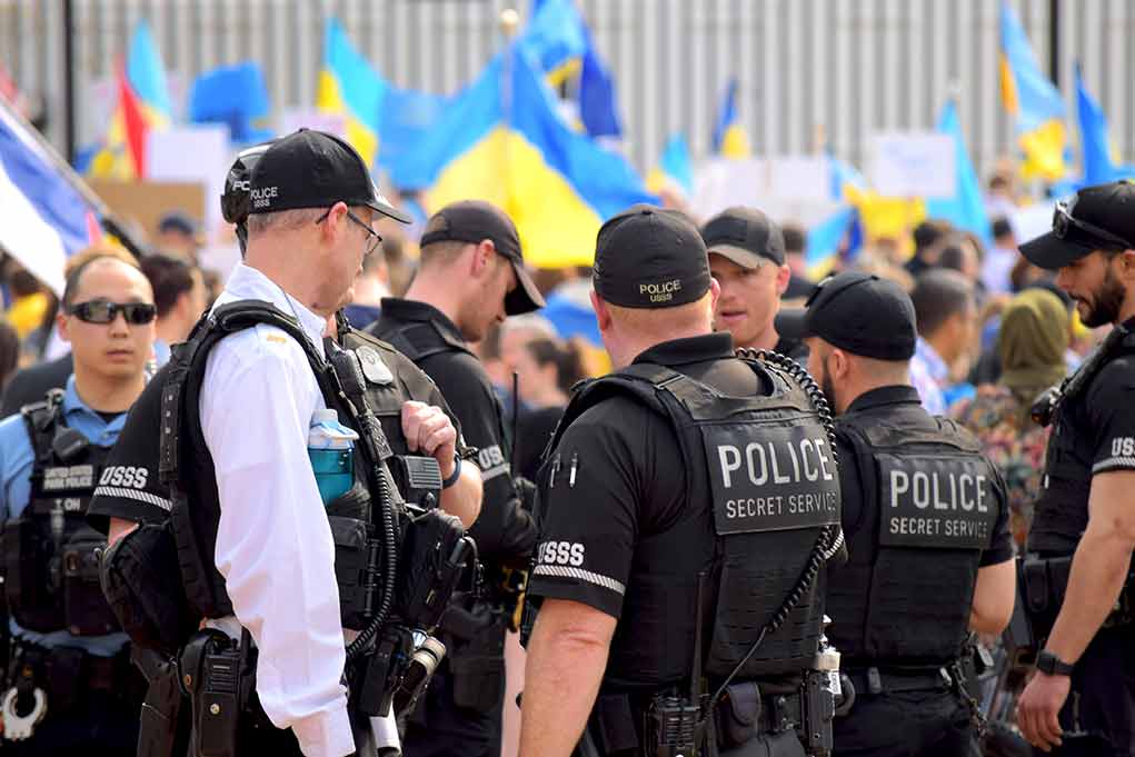 Police officers gathered near a crowd with flags
