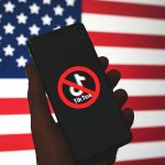Trump Weighs Options on TikTok’s ByteDance Divestment Amid Strategic Discussions Phone displaying TikTok ban symbol in front of flag