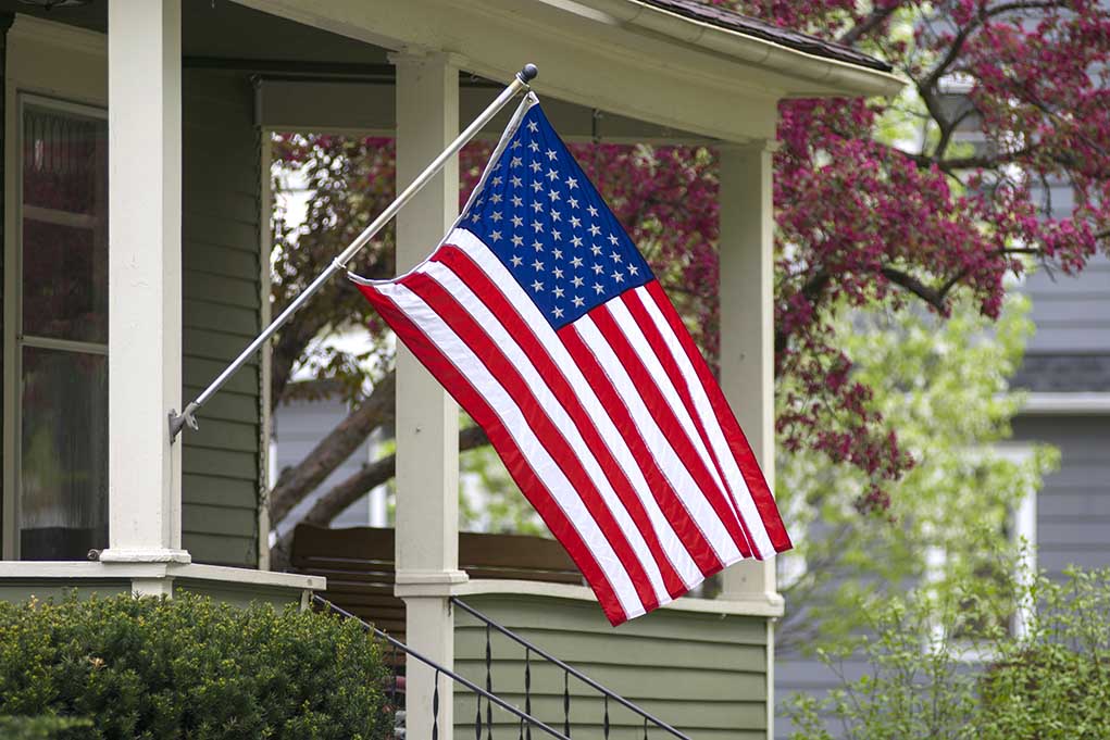 American flag hanging from a porch.