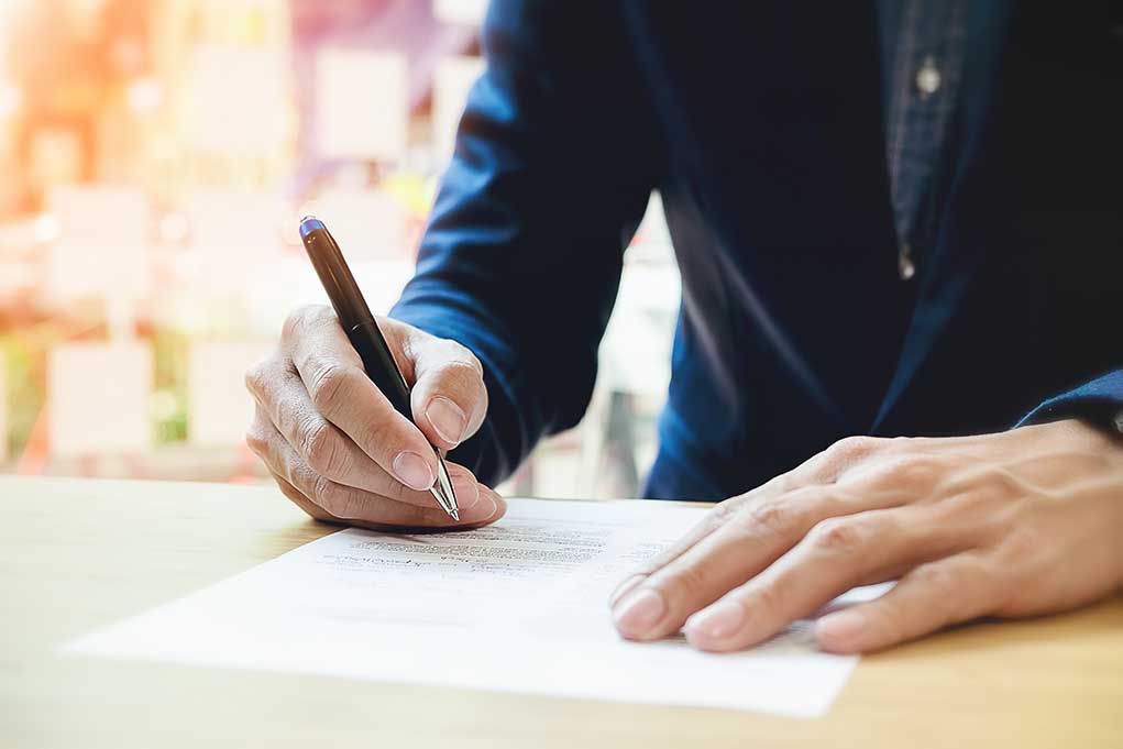613375877 featured image Person signing a document with a pen