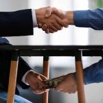 Handshake and exchange of money under the table