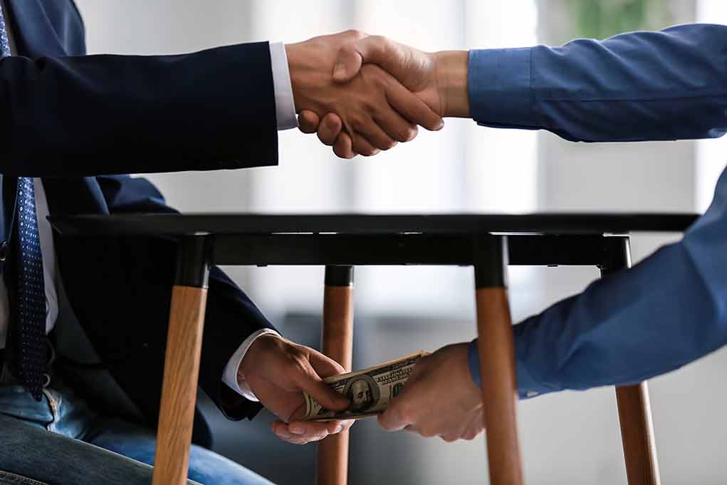 Handshake and exchange of money under the table