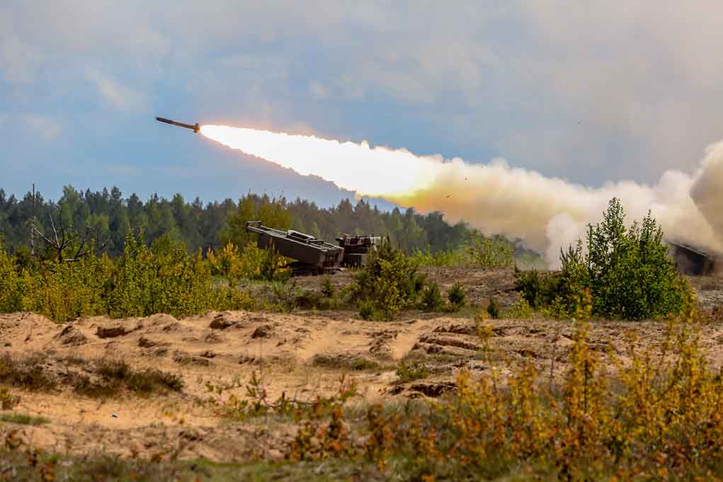 Military tank firing a missile in forest area