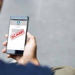 Massive FTC Fine SLAMS Tech Firm Over Lies Person reading a scam message on a smartphone