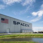 SpaceX building with American flag and launch pad