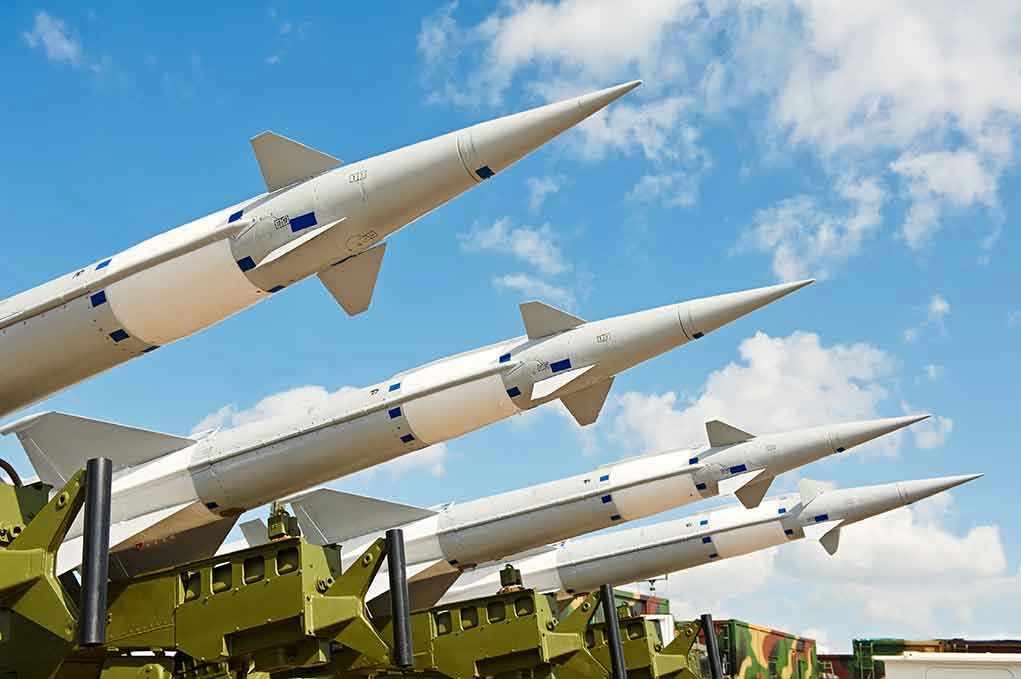 139772101 Multiple missiles pointed upward on launchers against blue sky