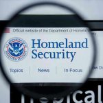 TRUMP WINS: Court Backs TPS End Magnifying glass showing Homeland Security website.