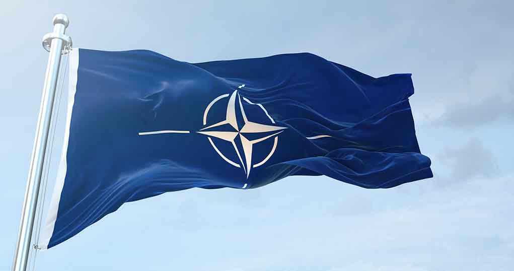1633919905 NATO flag waving against blue sky