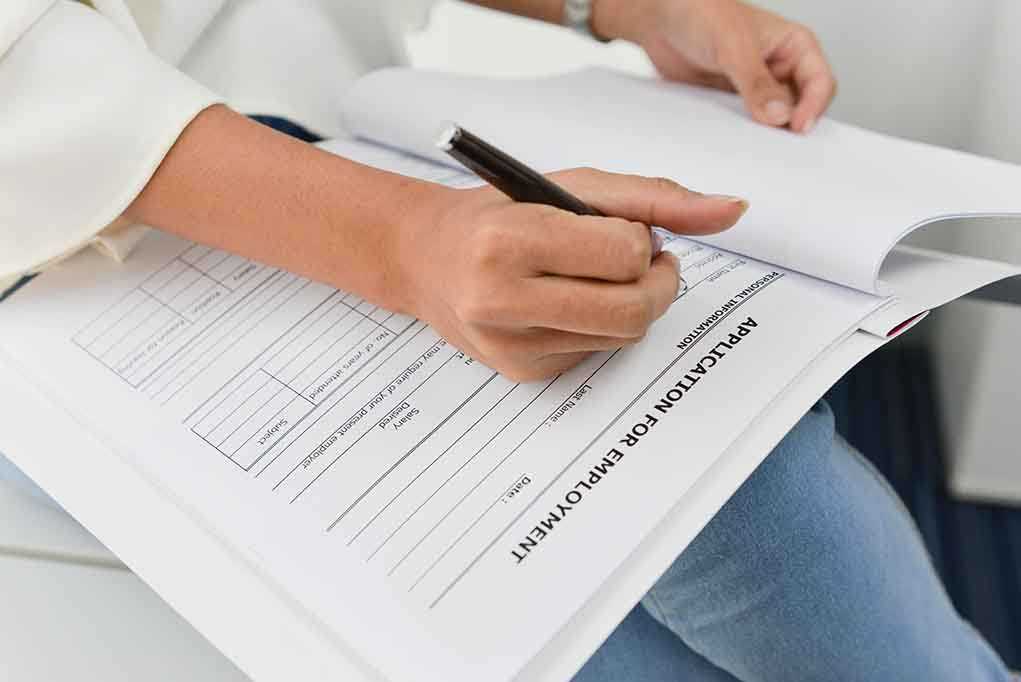 Person filling out job application form