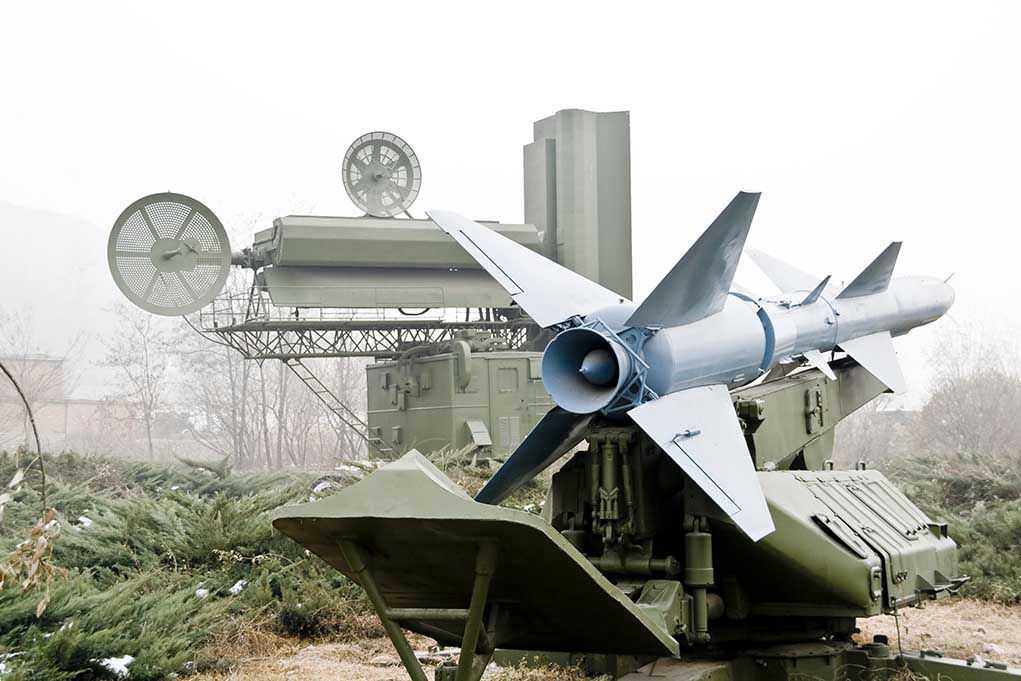 Military missile launcher with radar systems in a foggy field