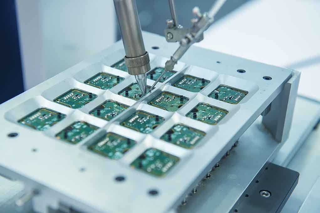 shutterstock_215575258.jpg Close up of a soldering machine working on circuit boards