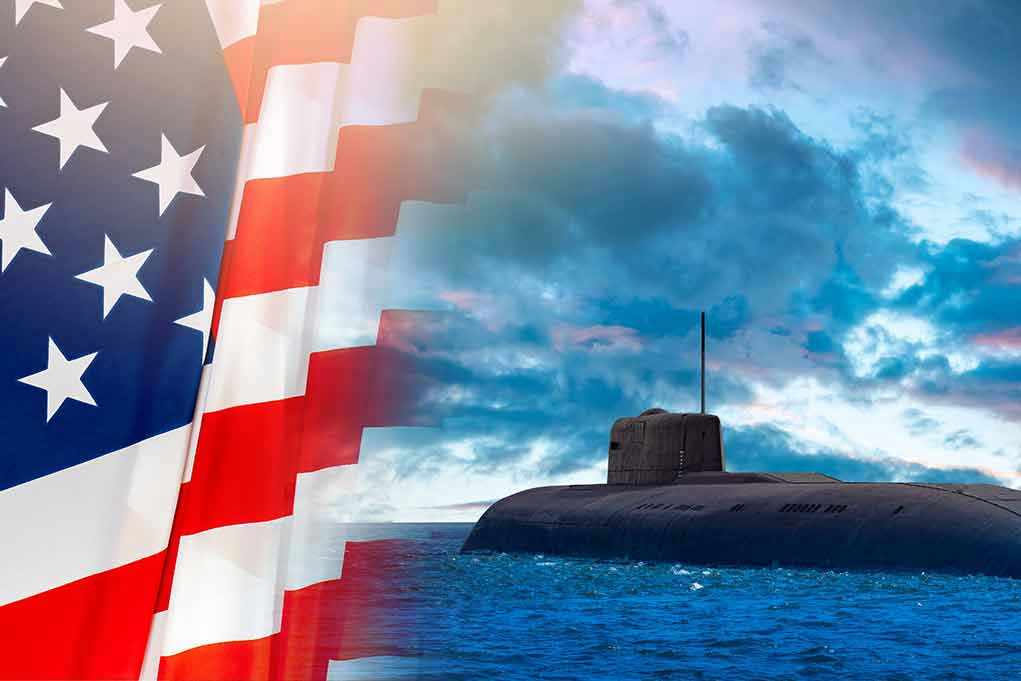 American flag and submarine at sea under a cloudy sky