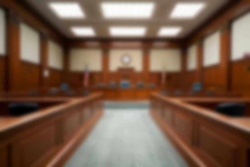 Empty courthouse courtroom with wooden benches and chairs