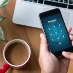 Brain BETRAYAL — Coffee’s Aging Time Bomb Typing privacy passcode on smartphone near laptop and coffee.