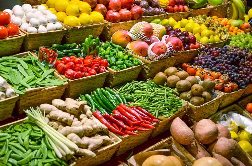 shutterstock_130707287.jpg A vibrant display of assorted fruits and vegetables in baskets at a market