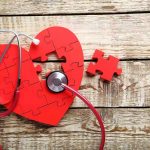 Shocking Truth: Plastics Damage Heart Tissue Red heart puzzle with stethoscope on wooden background.