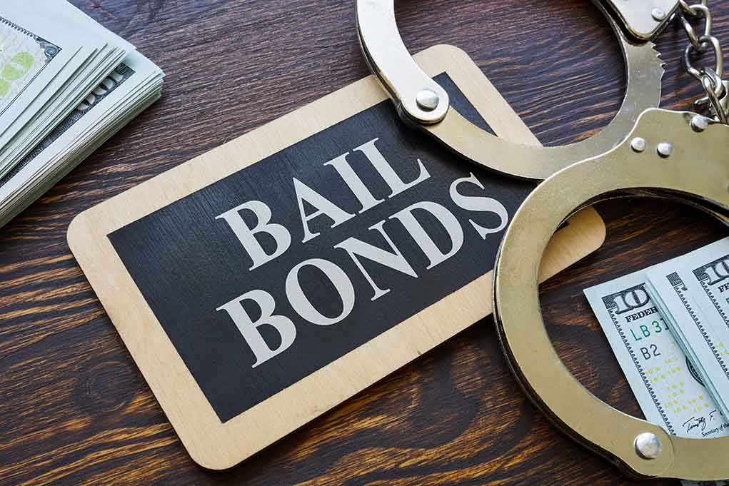 Bail bonds sign with handcuffs and stacks of cash
