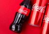 Trump Forces Coca-Cola’s SWEET Surrender Coca-Cola bottles and cans on red background.