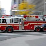 Firefighter Funds Abandoned for Blatant Election Power Play Red fire truck driving through city street crosswalk