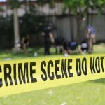 Couple ARRESTED After HORRIFYING Backyard Discovery Yellow crime scene tape blocking grassy area.