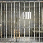 Shocking Verdict — Private Jail’s $42.75 Million Apology Empty rusty prison cell with a small window.