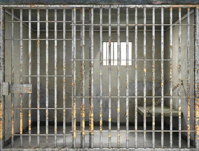 508424233 Empty rusty prison cell with a small window.