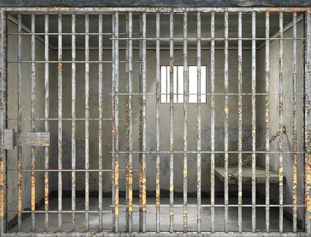 Empty rusty prison cell with a small window.