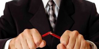 Person breaking red pencil with both hands