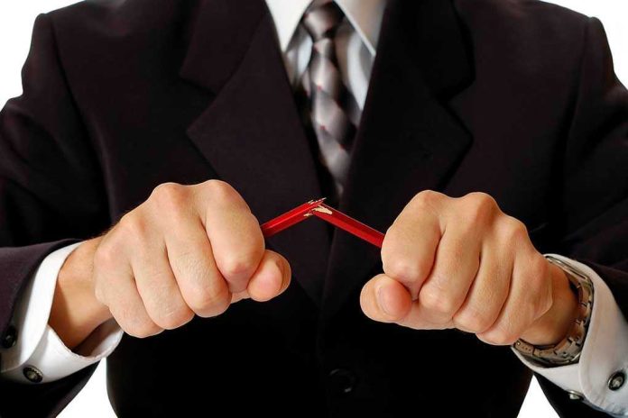 59756248 Person breaking red pencil with both hands