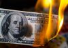 Fed Rate Cut BACKFIRES — Internal WAR Erupts Burning hundred-dollar bill with visible flames.