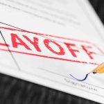 Close-up of a layoff notice with a signature line and a fountain pen