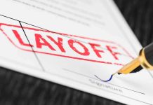 Close-up of a layoff notice with a signature line and a fountain pen