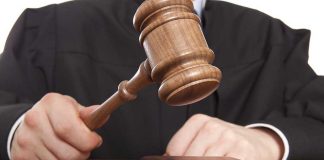 A judge holding a gavel above a wooden block