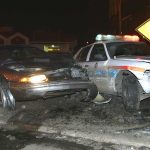 Armed Predator STRIKES Highway Crash Scene A damaged car and a police vehicle involved in a nighttime accident