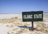 Shocking Data — Islam’s Growth In The US A weathered sign reading 'ISLAMIC STATE' in a barren landscape