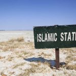 Shocking Data — Islam’s Growth In The US A weathered sign reading 'ISLAMIC STATE' in a barren landscape