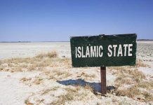 Shocking Data — Islam’s Growth In The US A weathered sign reading 'ISLAMIC STATE' in a barren landscape