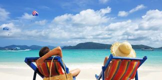 A couple relaxing on colorful beach chairs by the ocean