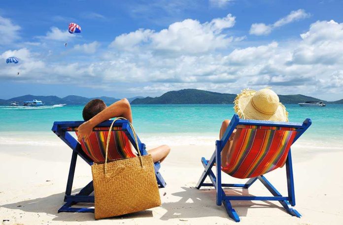 shutterstock_94709476.jpg A couple relaxing on colorful beach chairs by the ocean