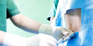 Healthcare professional administering an injection to a patient in a surgical setting