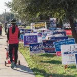 CA Braces for Battle — Pelosi’s Daughter Announces Candidacy Person walking with stroller past numerous election campaign signs.