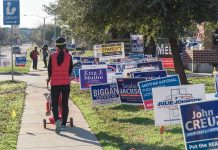 CA Braces for Battle — Pelosi’s Daughter Announces Candidacy Person walking with stroller past numerous election campaign signs.