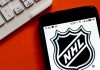 NHL Star’s SHOCKING $50K Scam Exposed NHL logo displayed on smartphone next to keyboard.
