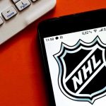 NHL logo displayed on smartphone next to keyboard.