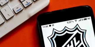 NHL logo displayed on smartphone next to keyboard.