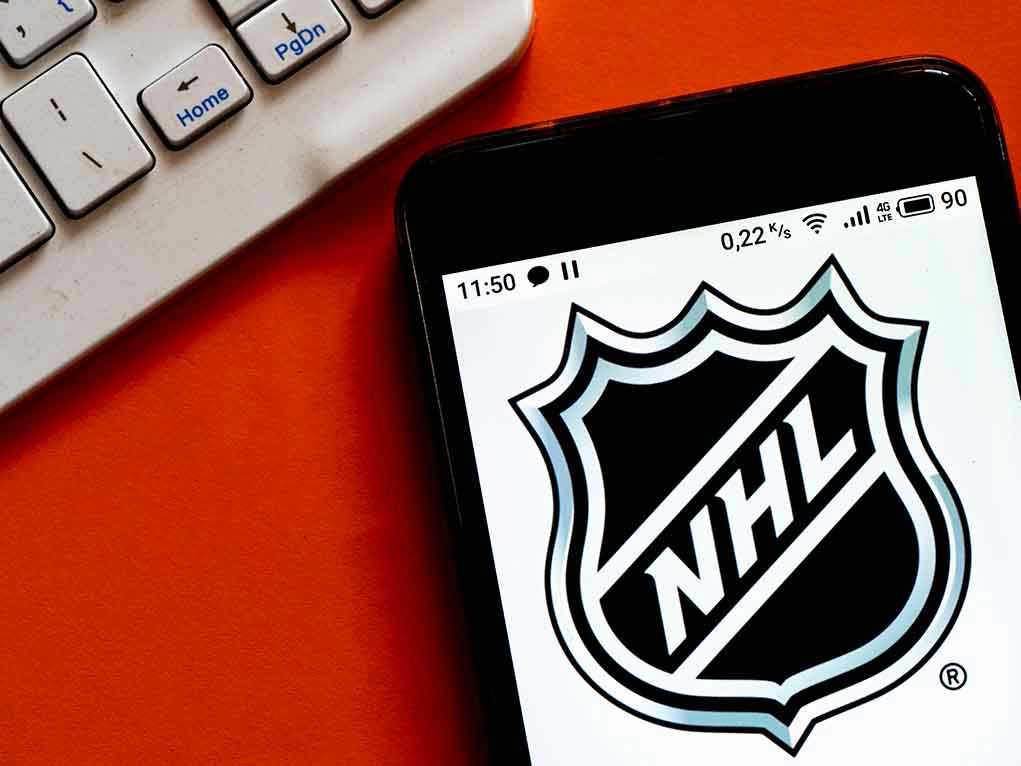 NHL logo displayed on smartphone next to keyboard.