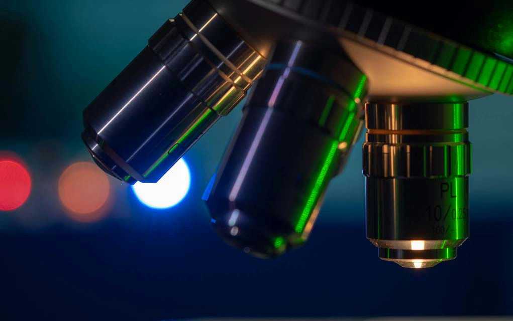 Closeup of microscope lenses with colorful background