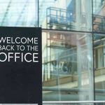 Welcome back to the office sign outside building.